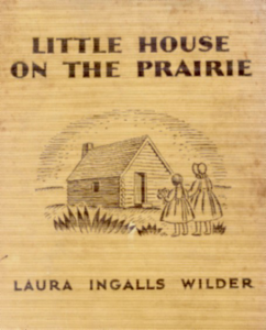 book cover showing a drawing of two girls looking at a log cabin