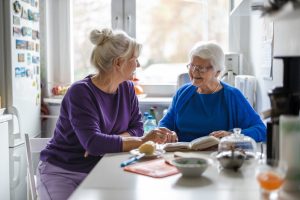 a mother and daughter sitting at a kitchen table